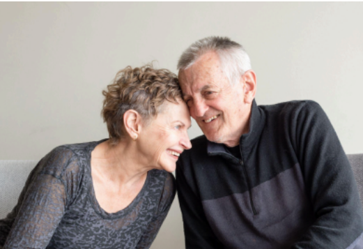  an older couple embracing lovingly. 